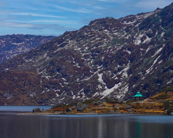 The high alpine water of Tsomgo Lake in East Sikkim below bare ridges